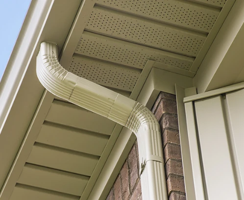 A view of a gutter and downspout from below.